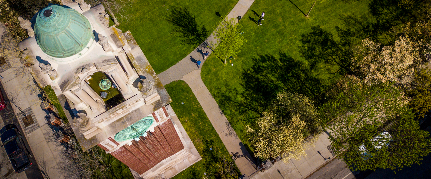 Aerial photo of the Carrie Tower from above, with portions of the Front Green in frame and students walking along the pathways.