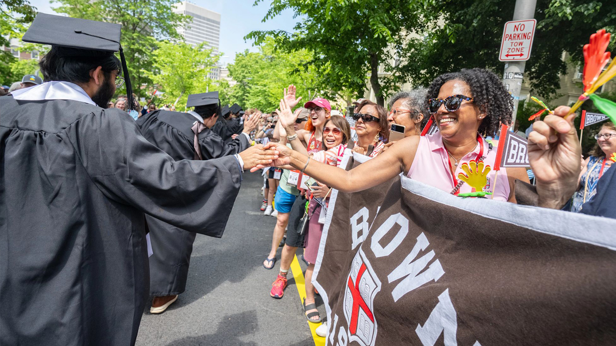 Alumni high fiving new grads during Brown Procession.