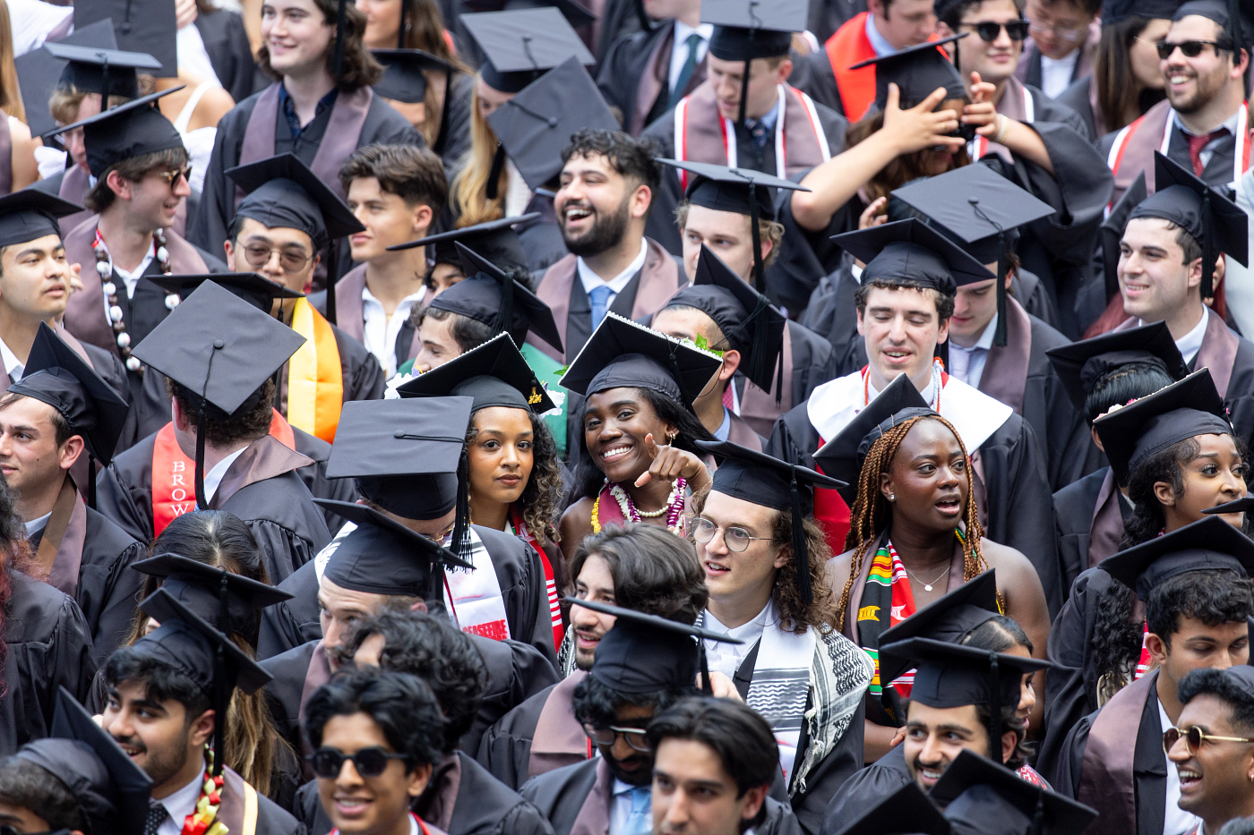 A crowd of students sitting in their cap and gowns during Brown Commencement.