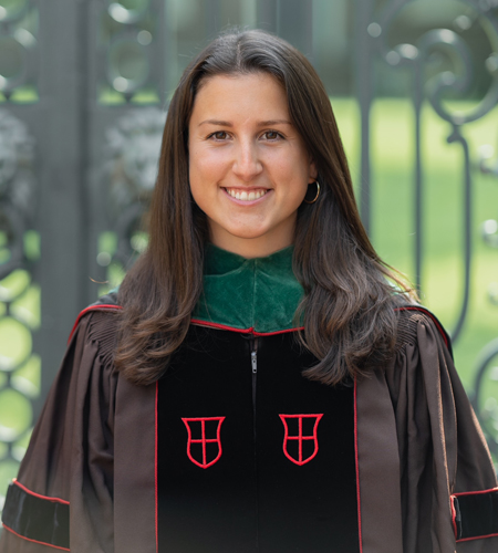 Katie Barry posing in front of the Van Wickle Gates at graduation