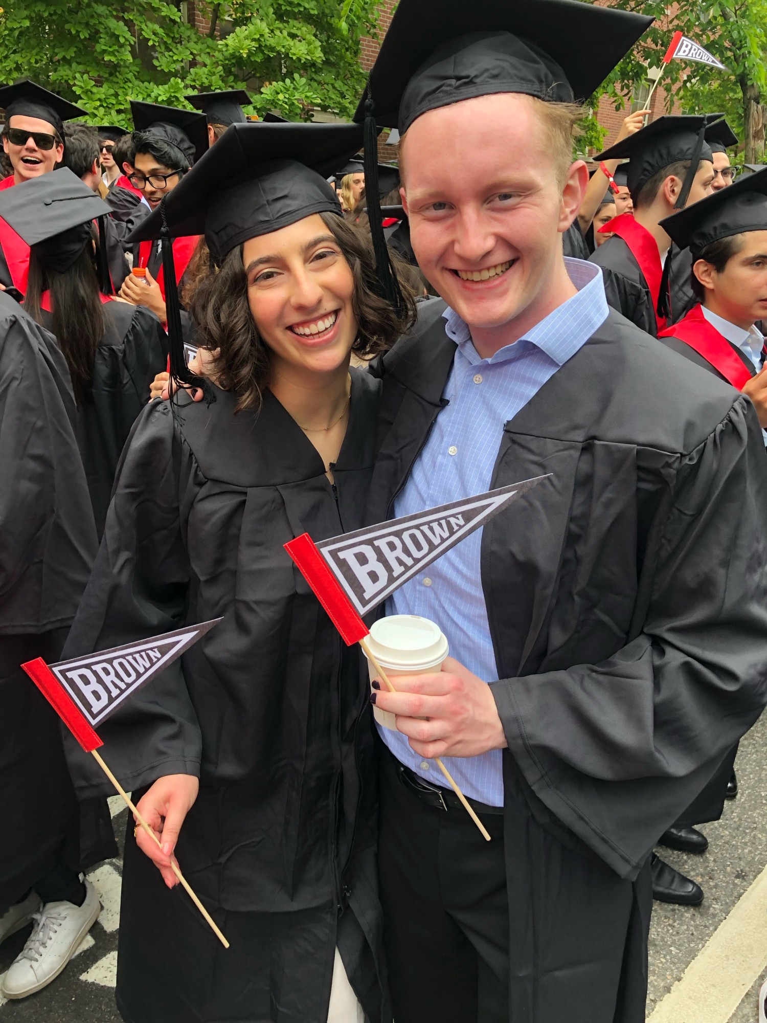 Caroline and Jake pose with Brown pennants during Commencement