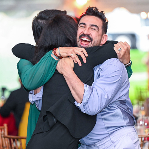 Three alums embracing during a Reunion event.