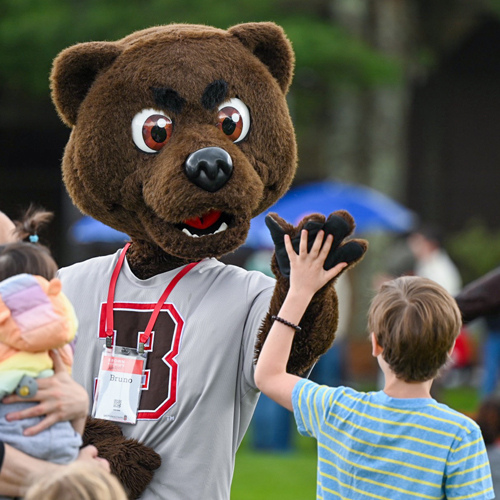 Bruno mascot high-fiving a child at Bruno's Block Party During Reunion