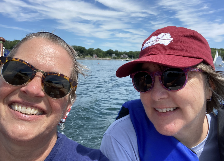 Close-up of Julie and Rebecca with a view of a lake in the background. 