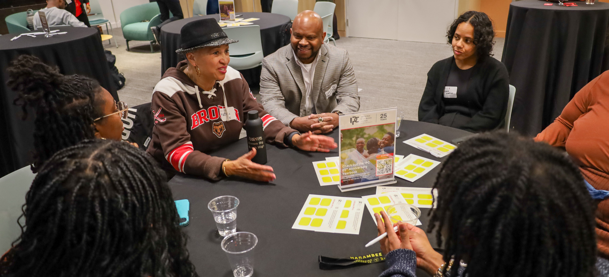 A group of Brown alumni seated around a table for discussion.
