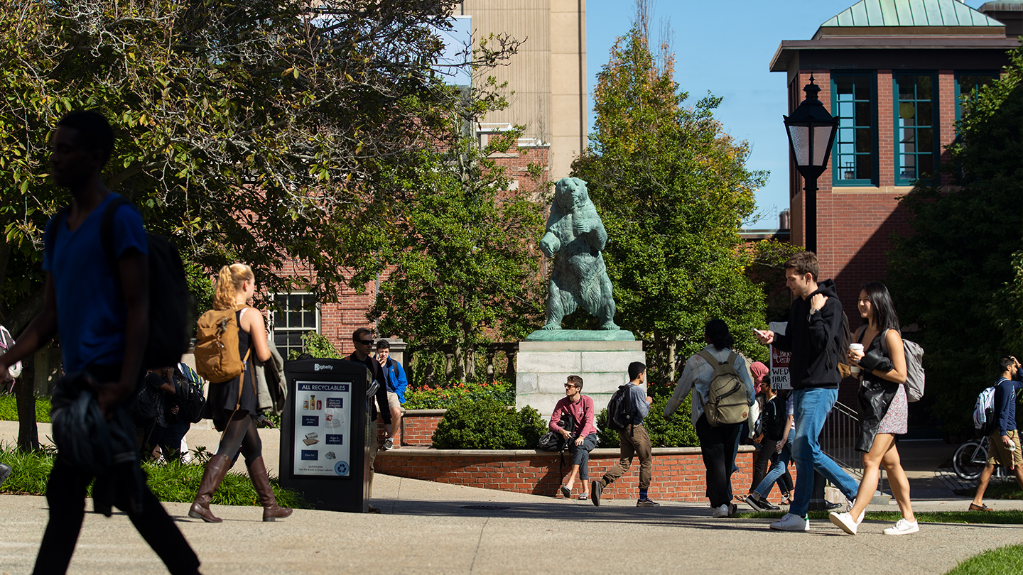 Students walking by the bronze Bruno statue on campus