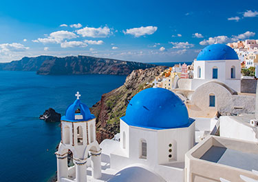 Church in Santorini with blue roofs on the coast.