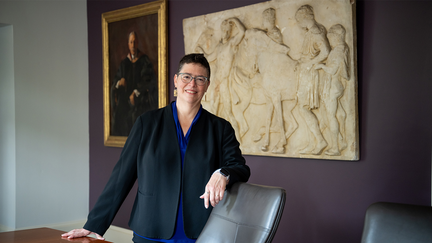 Leah VanWey standing in a conference room in Horace Mann House. Artwork is on the walls behind Leah.