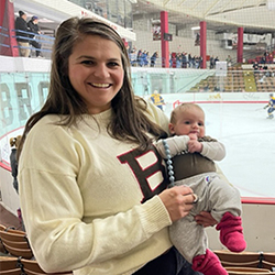 Molly Murphy holding her baby by the ice rink during a Brown hockey game