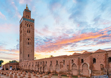 Tall Moroccan stone structure with beautiful sky.
