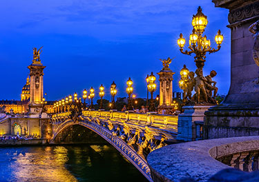Bridge lit up at night in Paris.