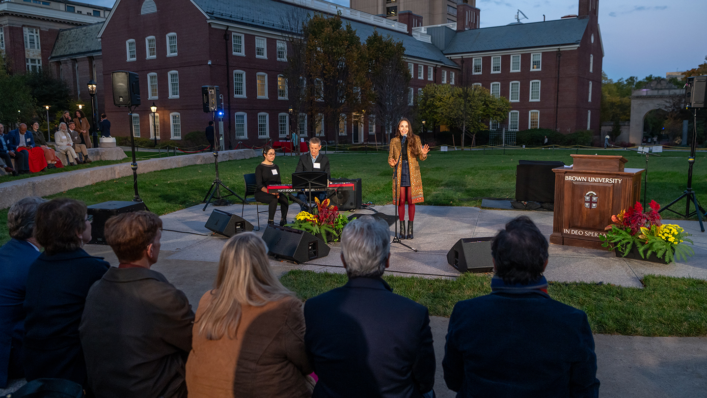 An alum singing into a microphone in the Sondheim Amphitheater