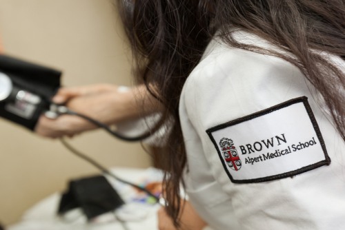 Student wearing white coat with Warren Alpert Medical School patch