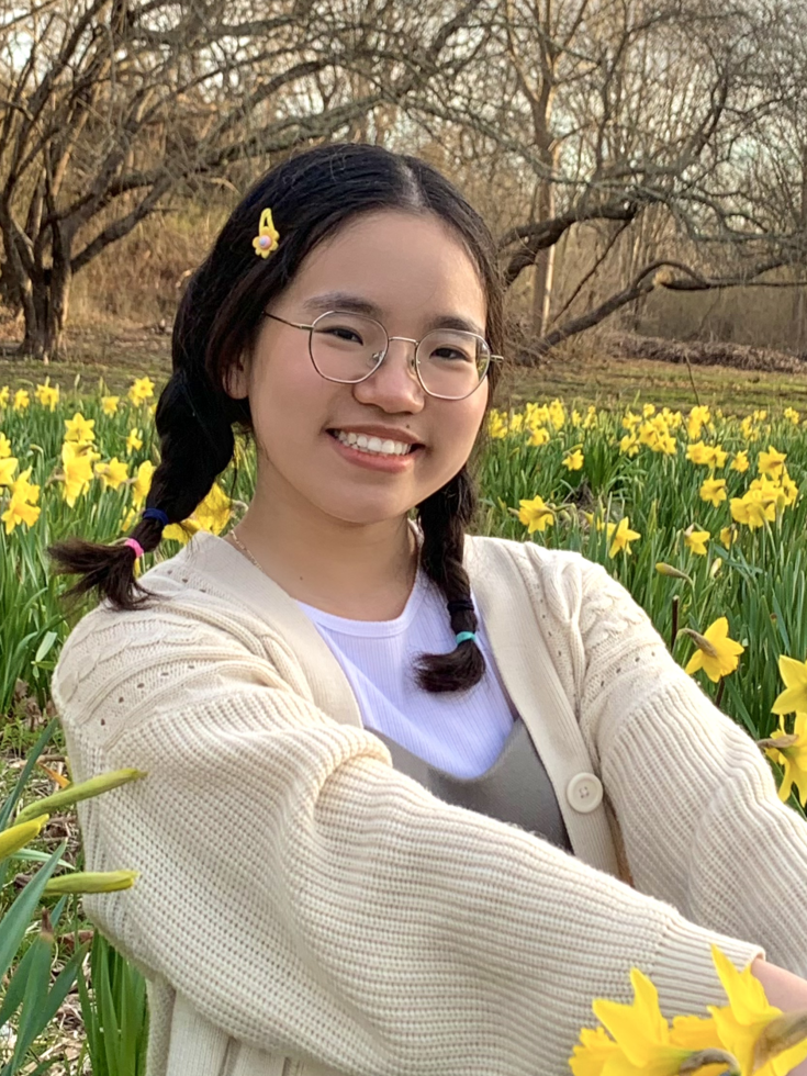 Demi Le posing for a photo in a field of flowers
