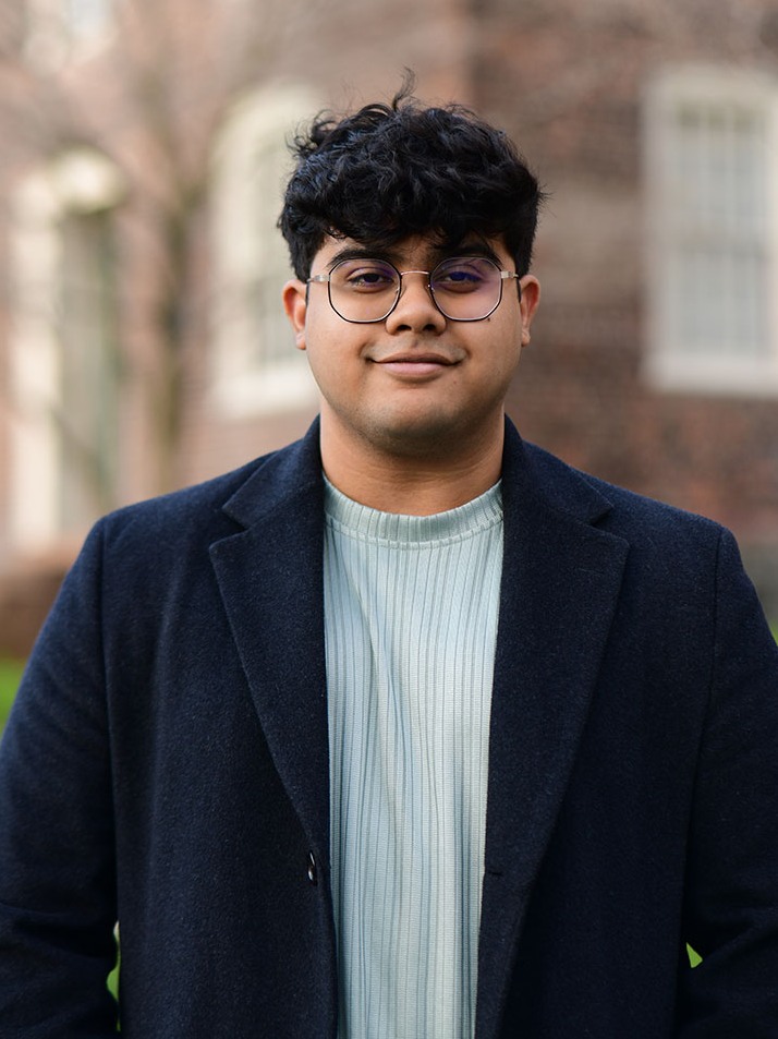 Robayet Hossain poses for a photo outside on Brown's campus in front of an academic building.