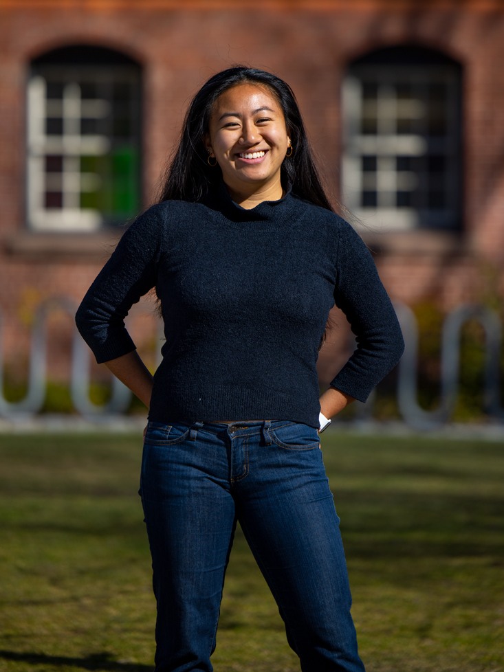Ayla Kim ’25 poses outside a brick building on Brown's campus