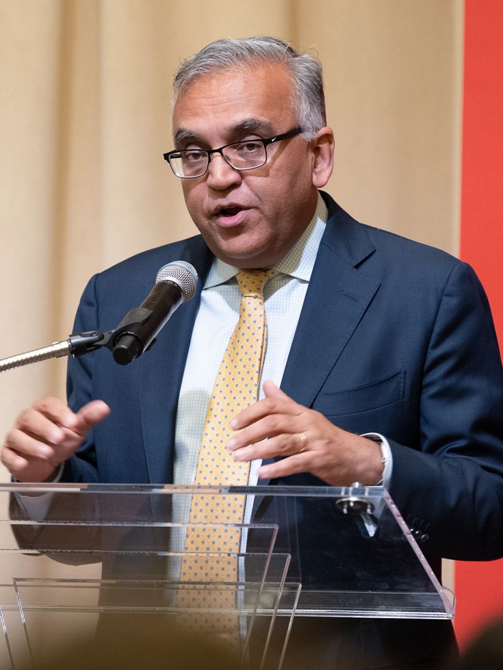 Ashish Jha stands behind a podium delivering a speech at a School of Public Health event.
