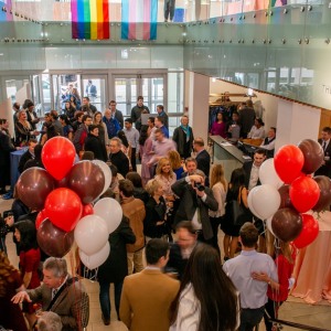 Brown medical event image of people in lobby with balloons