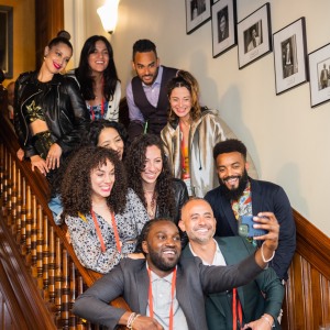 A group of alumni pose for a selfie photo on the staircase inside the Brown Center for Students of Color at a Reunion event