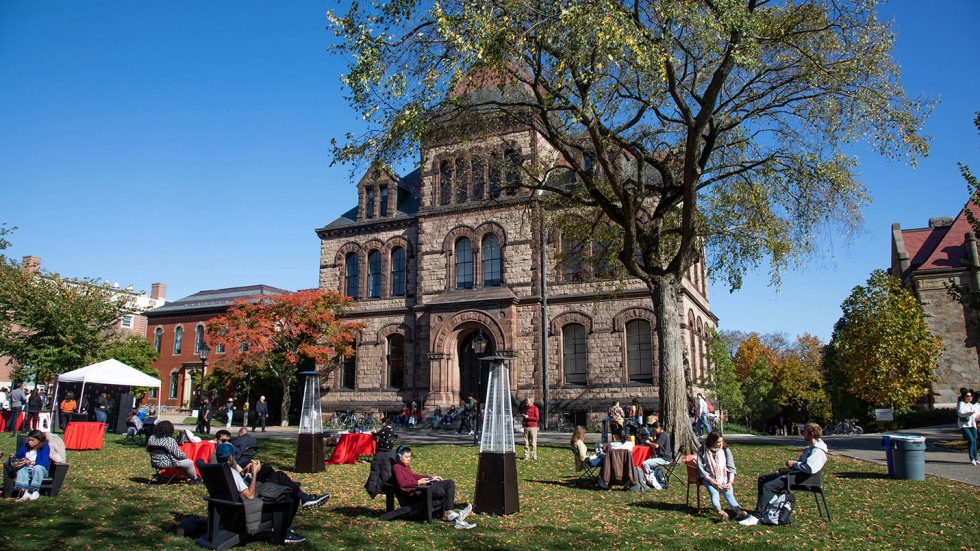 a beautiful fall day on campus with students, families, and alumni on the green