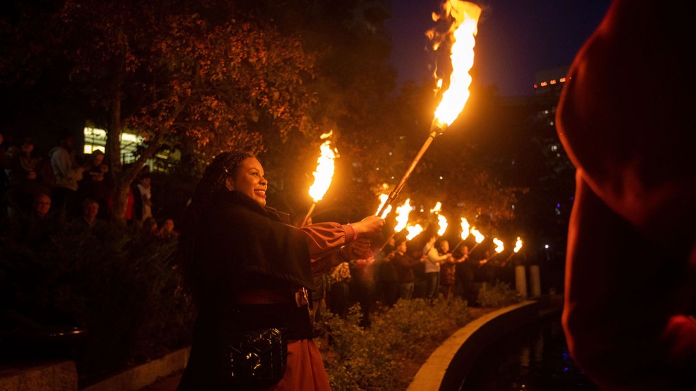 Andrea O'Neal '03 holding a torch at WaterFire 