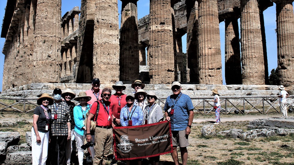 Alumni posing with Brown University banner in the Amalfi Coast Paestum