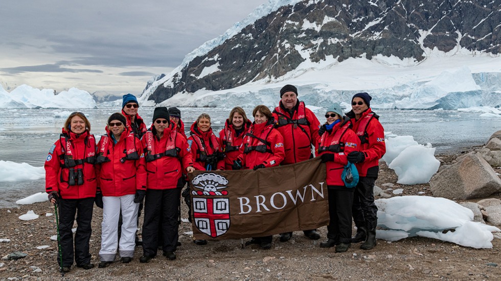 Alumni posing with Brown University banner in Antarctica