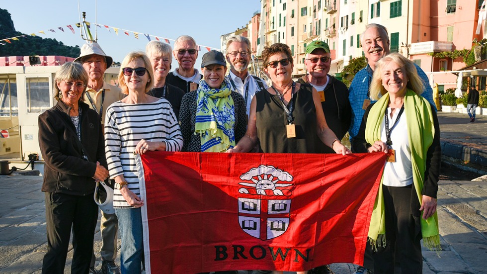 Alumni posing with Brown University banner in the town of Cinque Terre