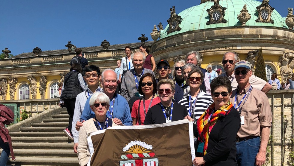 Alumni posing with Brown University banner on steps