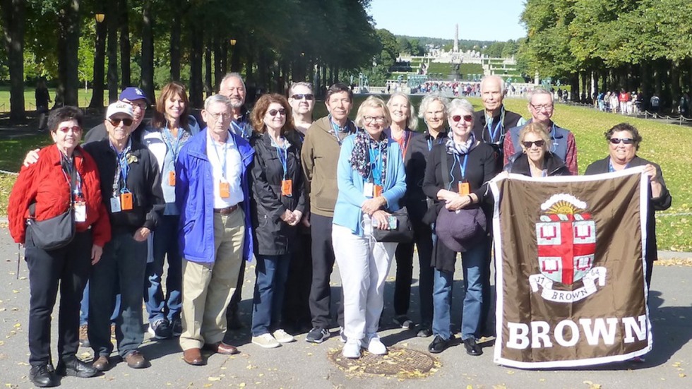Alumni posing with Brown University banner on the Nordic Magnificence trip