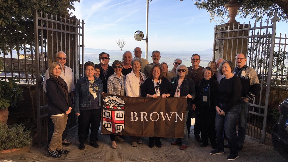 Alumni posing with Brown University banner in Tuscany