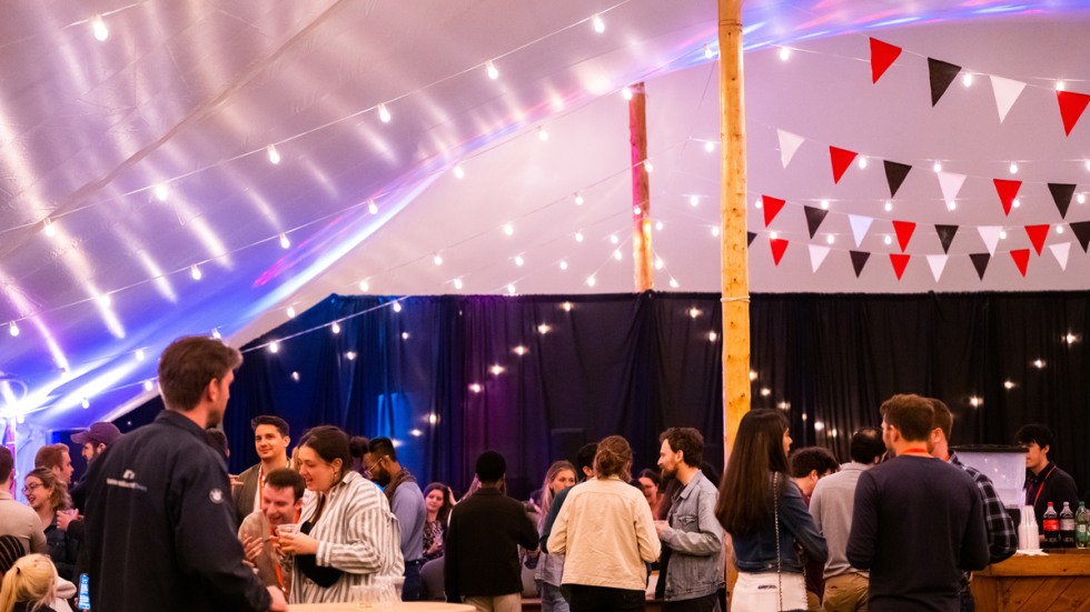 Alumni gather in a decorated tent for Pub Night 