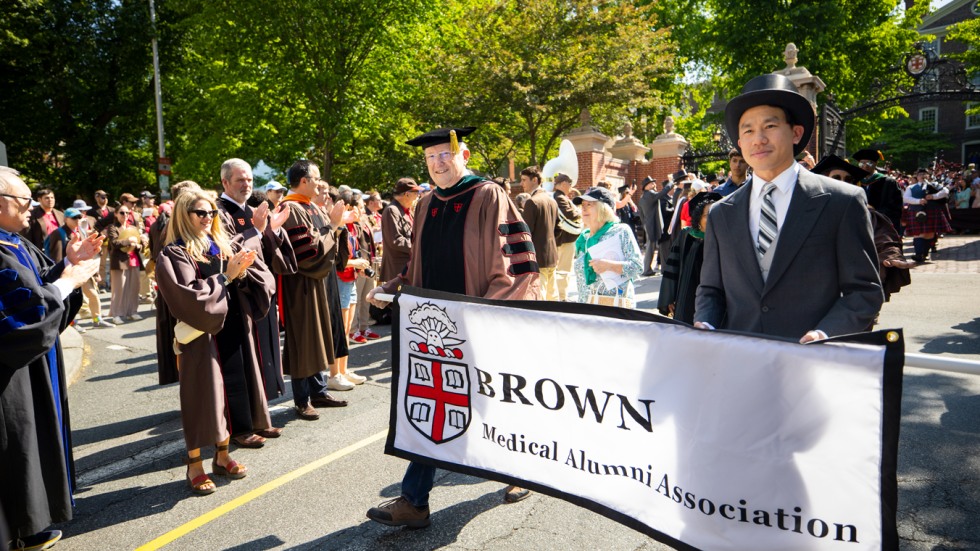 Medical alumni carrying the Brown Medical Alumni Association banner during Procession