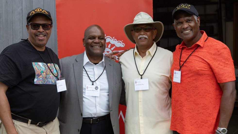 Four Brown alums pose for a photo together.