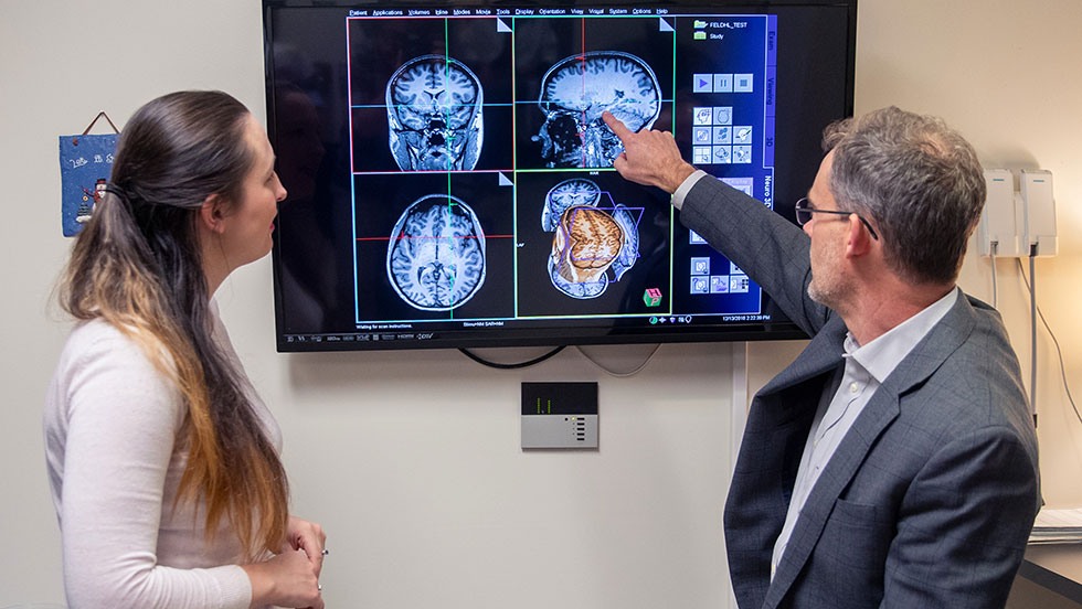 Two people looking at brain scan images