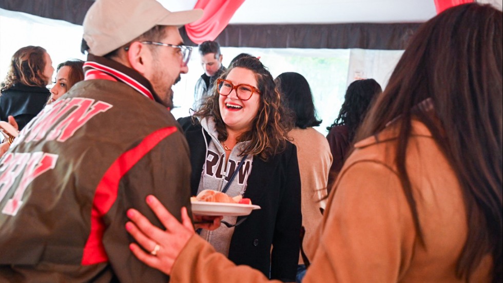 Two alums laughing under the tent at the BULAC breakfast.