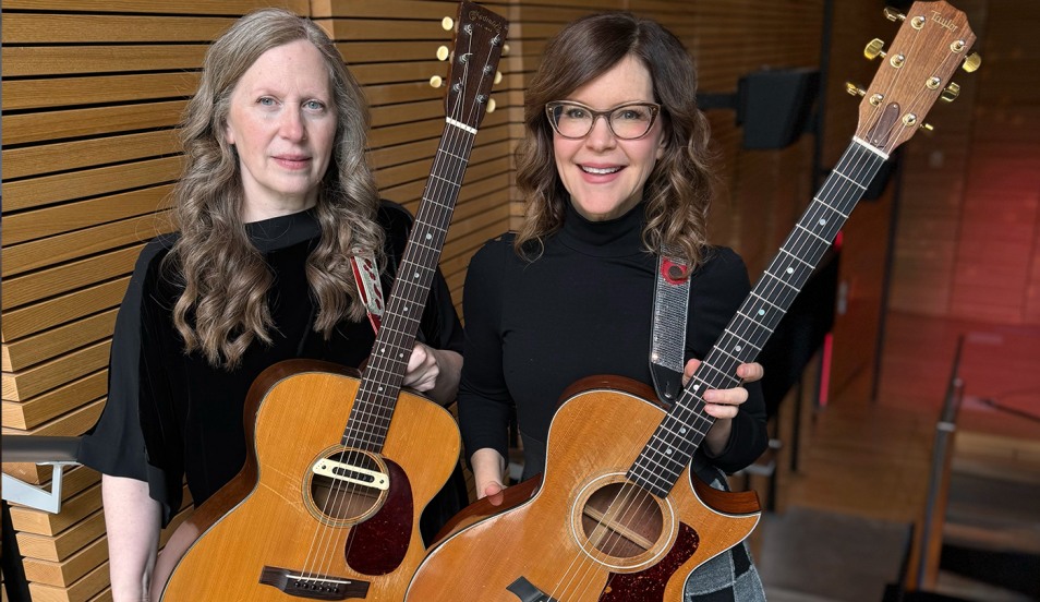 Liz Mitchell, left, and Lisa Loeb, right, holding guitars before their performance during Reunion Weekend.