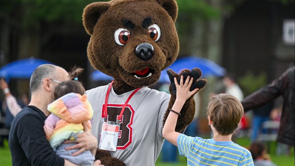Bruno the mascot gives a child a high five.