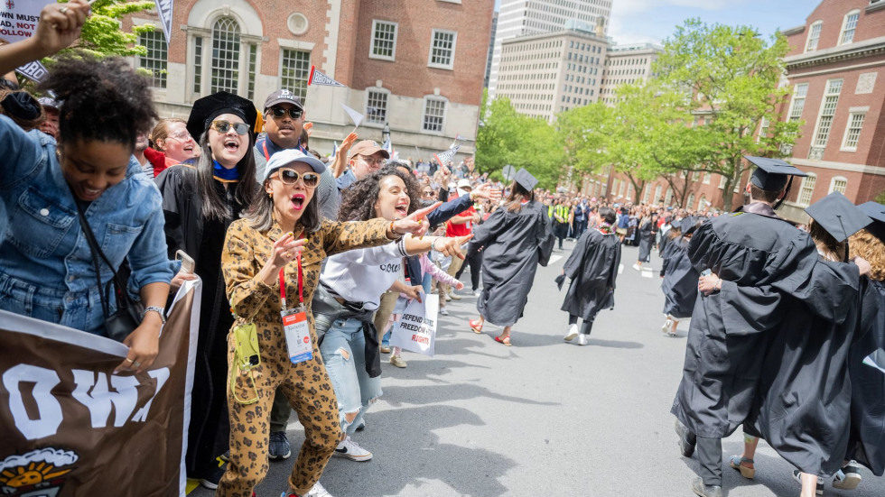 Reunioning alumni cheer on graduating students as they walk down the hill during Procession.