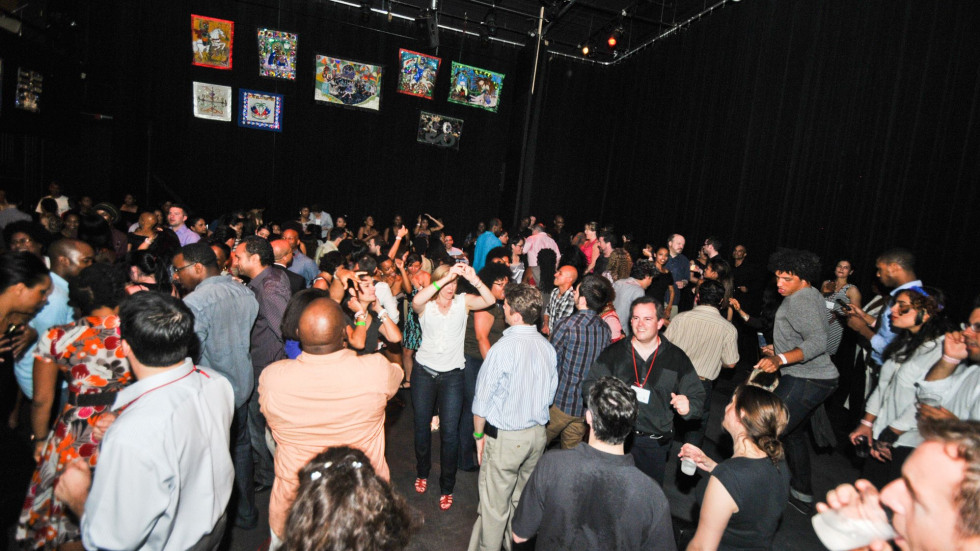 A large group of people are mingling and dancing 