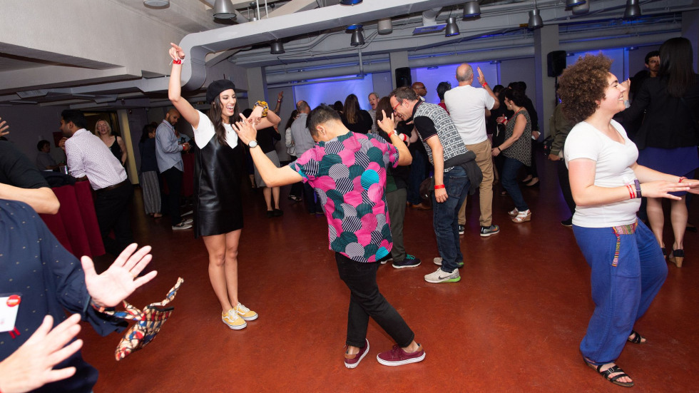 A group of people dancing together with their hands up. 