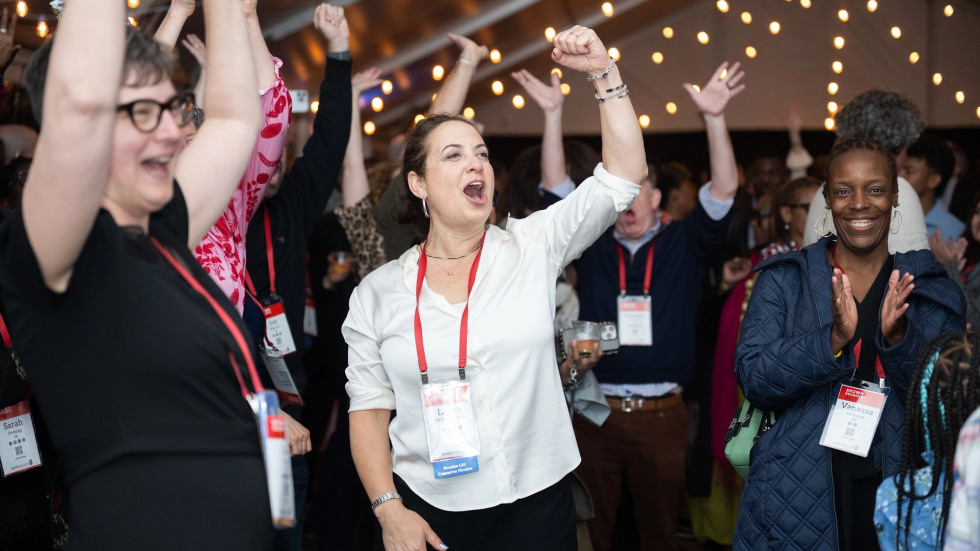 Participants at Funk Nite smiling and raising their arms in celebration. 