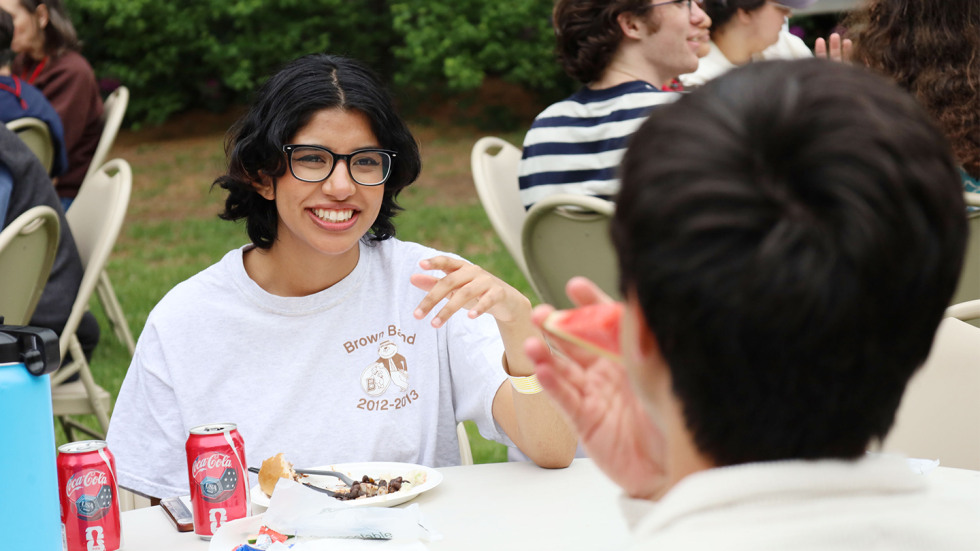 A woman wearing a Brown Band tshirt at the BBQ party.