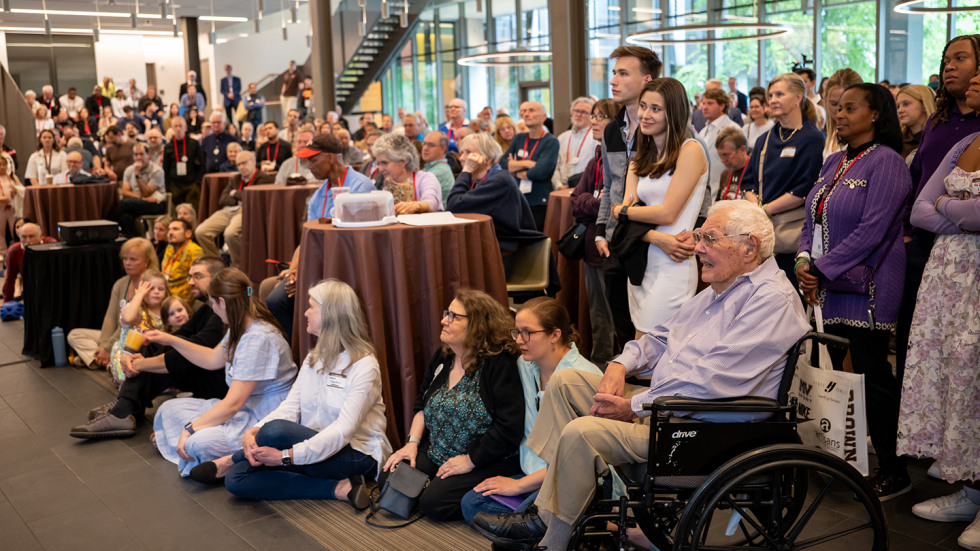 The attendees, including Professor Hazeltine, watching the movie about his legacy