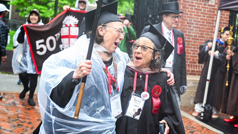 Two women walking arm in arm through the gates