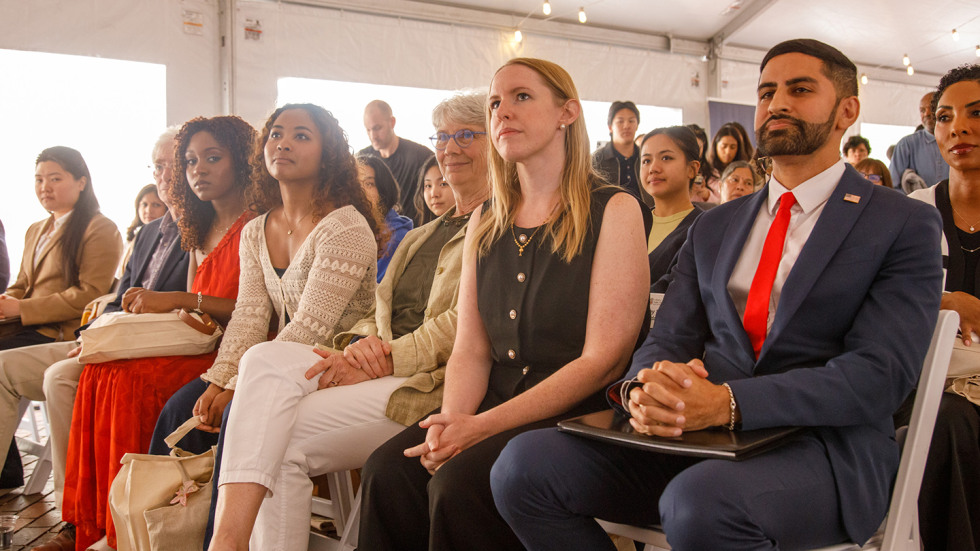 The two alum award recipients and other seated during the award presentation