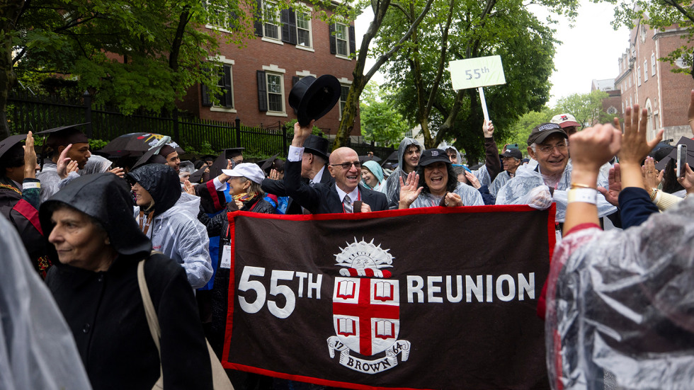 Two classmates from the 55th Reunion holding a banner in the procession