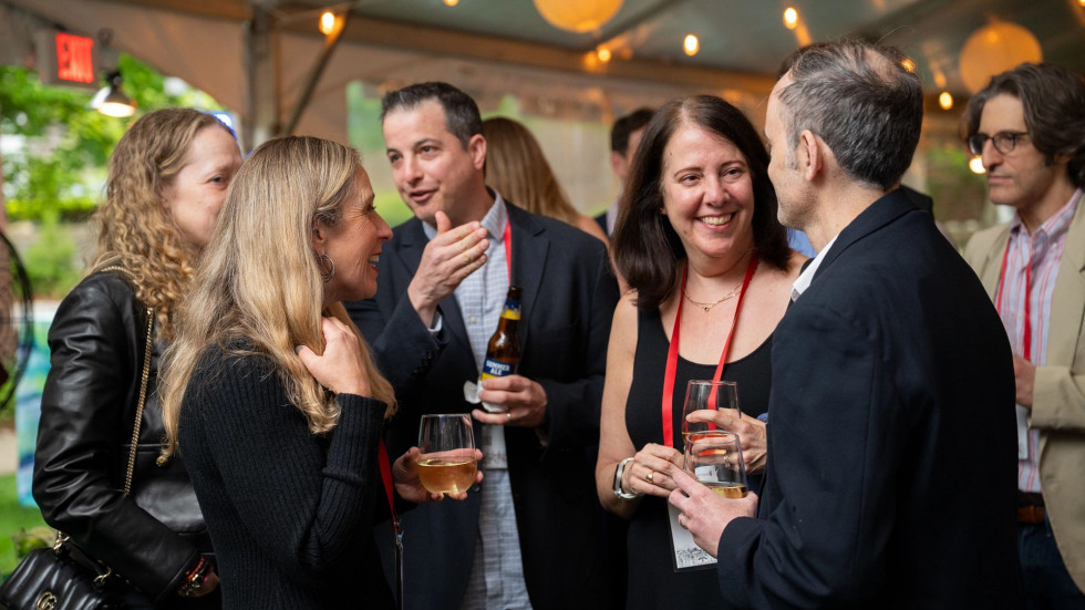 Brown alums gather at a class event cocktail hour under an event tent.