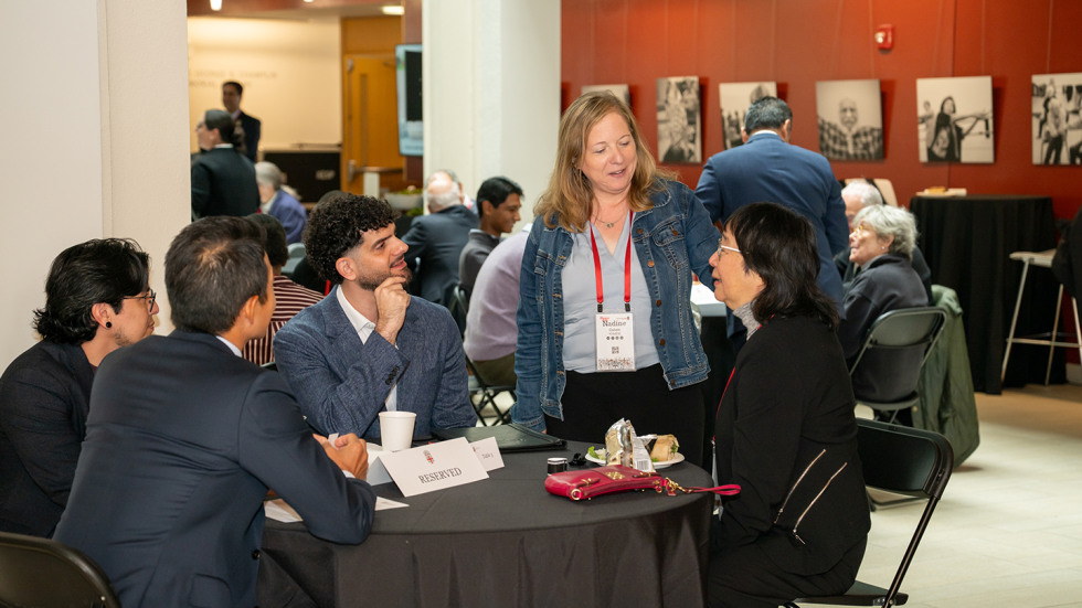 People chatting around a table after the lecture.