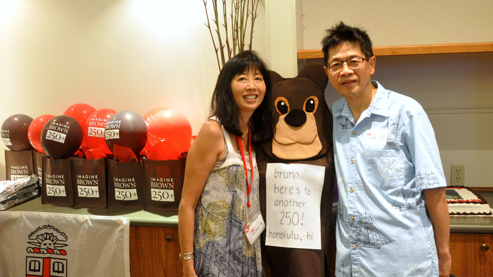 Lea Anne and Joseph Ng standing next to a brown bear sign that says "here's to another 250!"